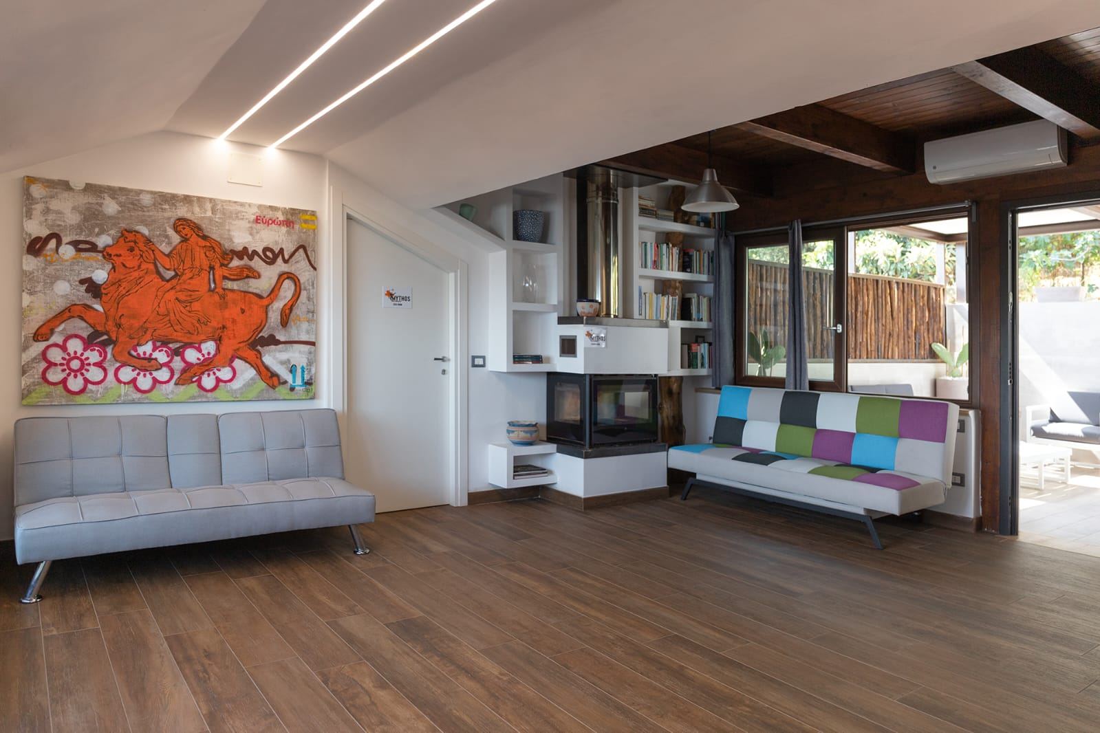 Salotto comune con divano di design e opera d'arte del B&B Mythos